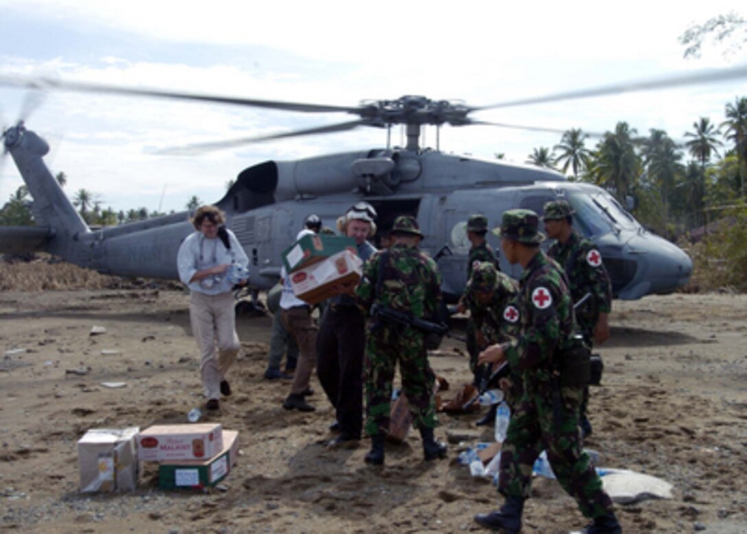 Indonesian Armed Forces and U.S. Navy personnel unload supplies from an SH-60F Seahawk helicopter in the village of Kewde Teunem on the island of Sumatra, Indonesia, on Jan. 2, 2005. Indonesian forces and sailors from the Abraham Lincoln Carrier Strike Group are conducting humanitarian operations in the wake of the tsunamis that struck Southeast Asia. The Seahawk is assigned to Helicopter Anti-Submarine Squadron 2. 