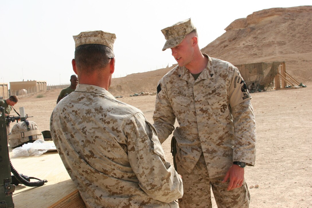 AL ASAD, Iraq ? Corporal Brandon Upton, range operations noncommissioned officer with 2nd Low Altitude Air Defense Battalion explains the range safety instructions to an oncoming range safety officer before the start of firing at the small arms range here. Upton was recently the recipient of a combat meritorious promotion.