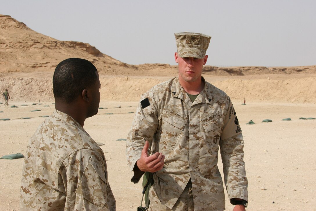 AL ASAD, Iraq ? Corporal Brandon Upton, range operations noncommissioned officer with 2nd Low Altitude Air Defense Battalion explains the range safety instructions to an oncoming corpsman before the start of firing at the small arms range here. Upton is a originally an Avenger mechanic who is temporarily being used in the range operations office here.