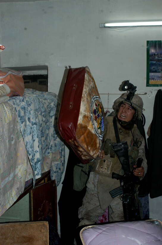 AR RAMADI Iraq (July 4, 2005) - Corporal Sergio Hernandez, a rifleman and team leader with 3rd Squad, 3rd Platoon, Company A, 1st Battalion, 5th Marine Regiment, quickly searches a house in the city here during a mission July 4. The 22-year-old from Hanford, Calif., and his fellow Marines captured six insurgents during a raid between 2 a.m. and 4 a.m., which made for a unique and memorable Independence Day. Hernandez has grown accustomed to being away from his family and friends during such holidays. The 2001 Hanford High School West Campus graduate is currently on his third deployment in support of Operation Iraqi Freedom. Photo by: Cpl. Tom Sloan