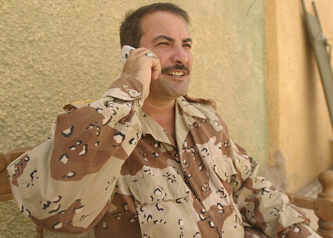 Hit, Al Anbar, Iraq (July 24, 2005)--Col. Mahdi A. Mohamed, a 39-year-old Mosul, Iraq native and commanding officer with Company "1", Iraq Intervention Force talks to a citizen on the tip line. (Official USMC Photo by Corporal Ken Melton)