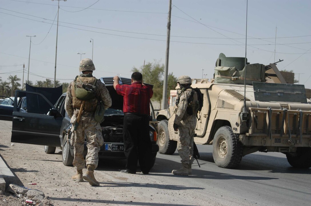 AR RAMADI Iraq (Aug. 4, 2005) -Marines with 2nd Platoon, Company A, 1st Battalion, 5th Marine Regiment, search an Iraqi man's car during a mission in the city here Aug. 4. The Marines captured an insurgent while conducting random vehicle and personnel searches throughout the city in an effort to capture insurgents and seize weapons. The man they caught was believed by Marine officials to be responsible for attacking Marines with improvised explosives. Photo by: Cpl. Tom Sloan