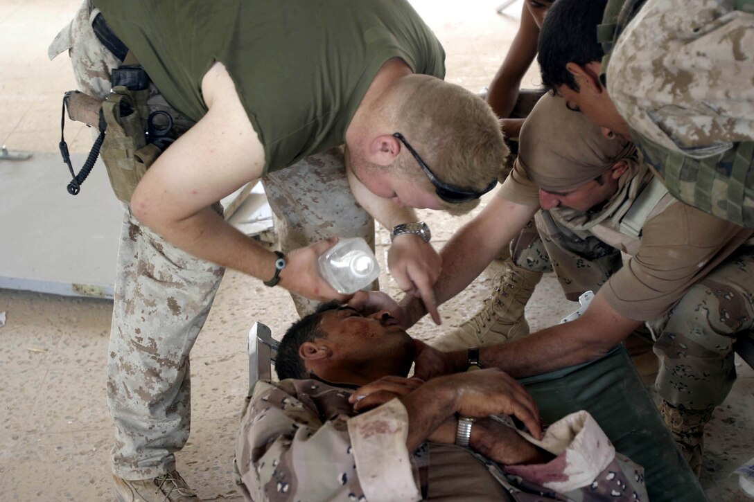 Hit, Iraq (September 4, 2005)--Petty Officer 3rd Class Aragorn T. Wold, a hospital corpsman from Company "I", 3rd Battalion, 25th Marines attends to an injured Iraqi soldier after an attack by insurgents who disrupted civilians receiving money from multinational forces damaged a bridge, caused more than 40 WIAs, one KIA for multinational forces and eight civilian casualties. (Official USMC Photo by Corporal Ken Melton)