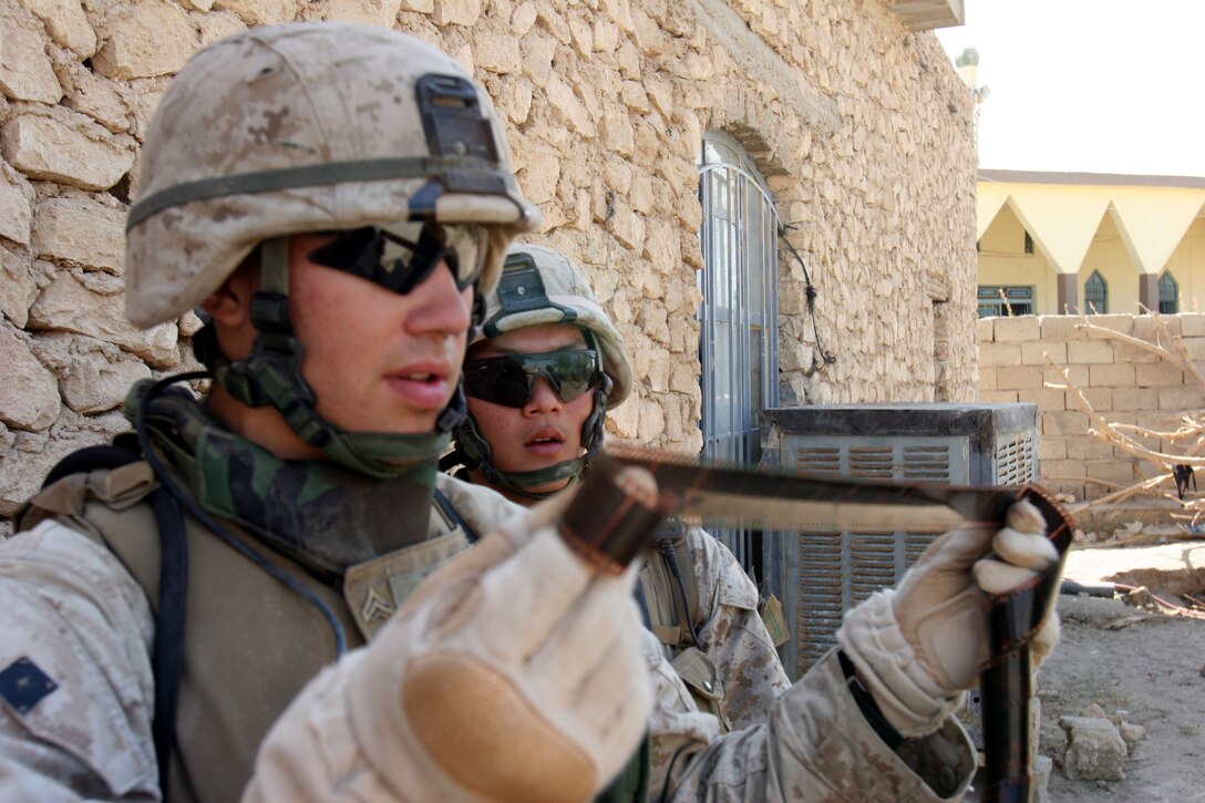 AR RAMADI, Iraq (October 4, 2005) - Two Marines from Company I examine a roll of film found while patrolling through the streets and alleyways of southern Ar Ramadi during Operation Bowie Oct. 4. The operation was a cooperative effort between the Iraqi Security Force, the army and the Marine Corps to capture and disrupt insurgent activities in the city during the weeks leading up to constitutional election. Photo by Cpl. Shane Suzuki