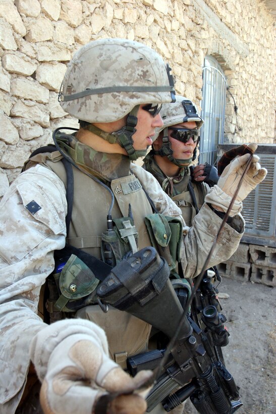 AR RAMADI, Iraq (October 4, 2005) - Two Marines from Company I examine a roll of film found while patrolling through the streets and alleyways of southern Ar Ramadi during Operation Bowie Oct. 4. The operation was a cooperative effort between the Iraqi Security Force, the army and the Marine Corps to capture and disrupt insurgent activities in the city during the weeks leading up to constitutional election. Photo by Cpl. Shane Suzuki