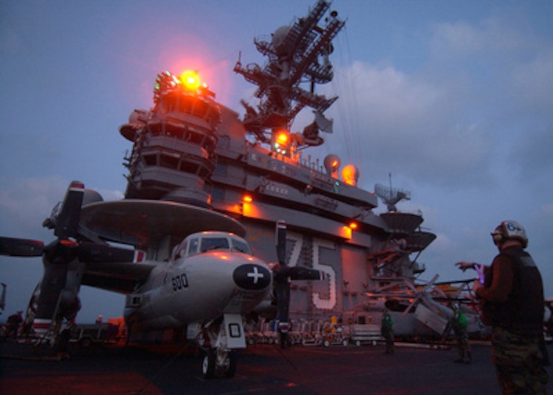A U.S. Navy plane captain signals the pilots of an E-2C Hawkeye to start their engines during evening flight operations on the flight deck of the aircraft carrier USS Harry S. Truman (CVN 75) operating in the Persian Gulf on Dec. 26, 2004. The Truman and its embarked Carrier Air Wing 3 is providing close air support and conducting intelligence, surveillance, and reconnaissance missions over Iraq. The plane captain is assigned to Fixed Wing Carrier Airborne Early Warning Squadron 126. 