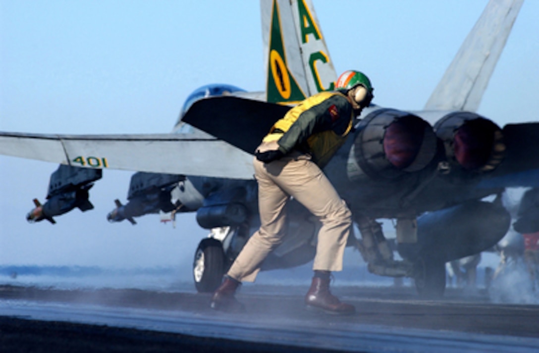Navy Lt. Lamar Bradley, a flight deck crewman know as a shooter, recovers after signaling an F/A-18 Hornet to launch from the flight deck of the aircraft carrier USS Harry S. Truman (CVN 75) on Dec. 29, 2004. The Truman and its embarked Carrier Air Wing 3 is providing close air support and conducting intelligence, surveillance, and reconnaissance missions over Iraq. The Hornet is assigned to the Fighter Attack Squadron 105. 