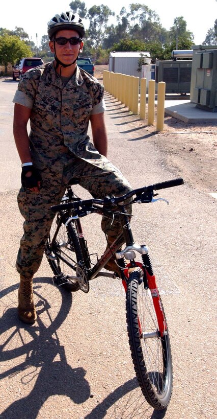 Corporal Kenny V. Mendez, military policeman, Provost Marshal's Office, Marine Corps Air Station Miramar, rests after his warm up drills and looks on as his fellow officers go through the drills before heading out to the training course Oct. 4. The air station will be implementing bike patrols through the housing areas on the air station.