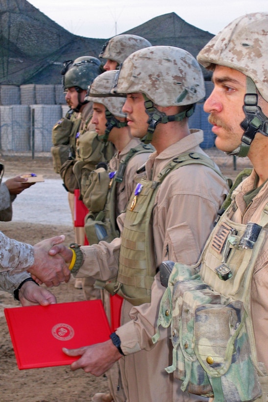 Cpl. John Stanz of the 24th Marine Expeditionary Unit’s Reconnaissance and Surveillance Platoon shakes hands with the MEU commander, Col. Ronald J. Johnson after receiving his Purple Heart Medal during a ceremony at Forward Operating Base Kalsu, Iraq, Jan. 4.::n::The 24th MEU continues its counter-insurgency in northern Babil province.::n::::n::(Official USMC Photo by Lance Cpl. Caleb J. Smith. This photo is cleared for release.)::n::