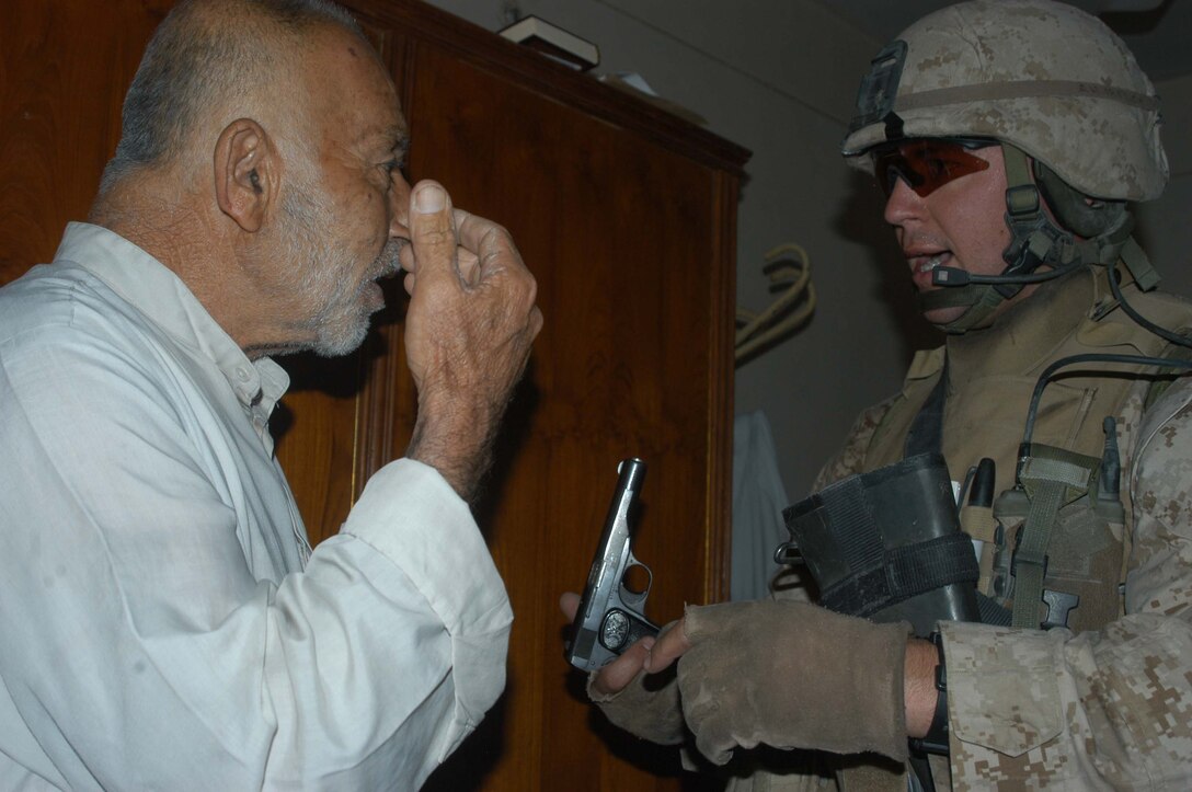 AR RAMADI, Iraq (May 27, 2005) - During a mission in the city here, Staff Sgt. James M. Hussey, the platoon sergeant for 4th Platoon, Company A, 1st Battalion, 5th Marine Regiment, questions an Iraqi man about a pistol his Marines found in his house. The 28-year-old from Poughkeepsie, N.Y., led his fellow 4th Platoon warriors on a four-hour aggressive-foot-patrol through several neighborhoods and the city's marketplace. The Marines searched 12 houses and talked to numerous locals during the mission, which was conducted in an attempt to stifle insurgent activity and inform citizens why Marines and coalition forces are occupying Ramadi. The Marines handed out pro-coalition forces and pro-Iraqi government fliers, which had a number to call coalition forces to report insurgent activity. Photo by: Cpl. Tom Sloan   .