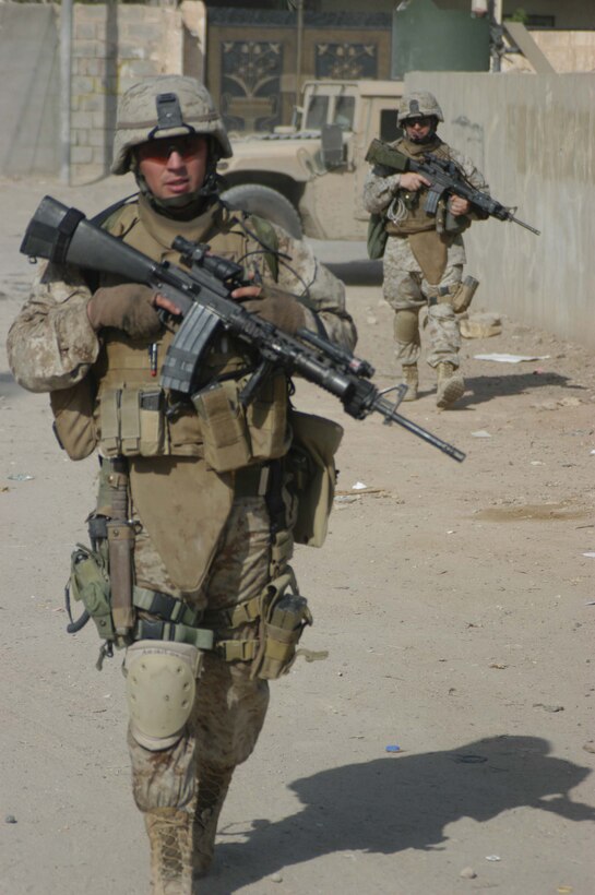 AR RAMADI, Iraq (May 27, 2005) -Staff Sgt. James M. Hussey, the platoon sergeant for 4th Platoon, Company A, 1st Battalion, 5th Marine Regiment, patrols through a street here during a mission with his Marines. The 28-year-old from Poughkeepsie, N.Y., led his fellow 4th Platoon warriors on a four-hour aggressive-foot-patrol through several neighborhoods and the city's marketplace. The Marines searched 12 houses and talked to numerous locals during the mission, which was conducted in an attempt to stifle insurgent activity and inform citizens why Marines and coalition forces are occupying Ramadi. The Marines handed out pro-coalition forces and pro-Iraqi government fliers, which had a number to call coalition forces to report insurgent activity. Photo by: Cpl. Tom Sloan