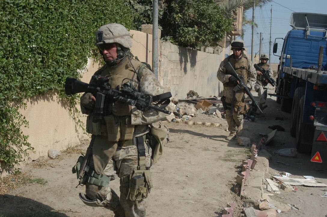 AR RAMADI, Iraq (May 27, 2005) -Two Marines with 4th Platoon, Company A, 1st Battalion, 5th Marine Regiment, follow their platoon sergeant, Staff Sgt. James M. Hussey, during a mission in the city here. The 28-year-old from Poughkeepsie, N.Y., led his fellow 4th Platoon warriors on a four-hour aggressive-foot-patrol through several neighborhoods and the city's marketplace. The Marines searched 12 houses and talked to numerous locals during the mission, which was conducted in an attempt to stifle insurgent activity and inform citizens why Marines and coalition forces are occupying Ramadi. The Marines handed out pro-coalition forces and pro-Iraqi government fliers, which had a number to call coalition forces to report insurgent activity. Photo by: Cpl. Tom Sloan