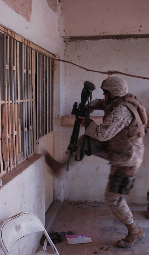 AR RAMADI, Iraq (May 27, 2005) - Lance Cpl. Phillip R. Dunseath, a rifleman with 3rd Squad, 4th Platoon, Company A, 1st Battalion, 5th Marine Regiment, kicks a locked door to a residence here he and his Marines need to search during a mission. The 22-year-old from Donora, Pa., who's in Iraq a third time supporting Operation Iraqi Freedom, and his fellow 4th Platoon warriors conducted a four-hour aggressive-foot-patrol through several neighborhoods and the city's marketplace. The Marines searched 12 houses and talked to numerous locals during the mission, which was conducted in an attempt to stifle insurgent activity and inform citizens why Marines and coalition forces are occupying Ramadi. The Marines handed out pro-coalition forces and pro-Iraqi government fliers, which had a number to call coalition forces to report insurgent activity. Photo by: Cpl. Tom Sloan