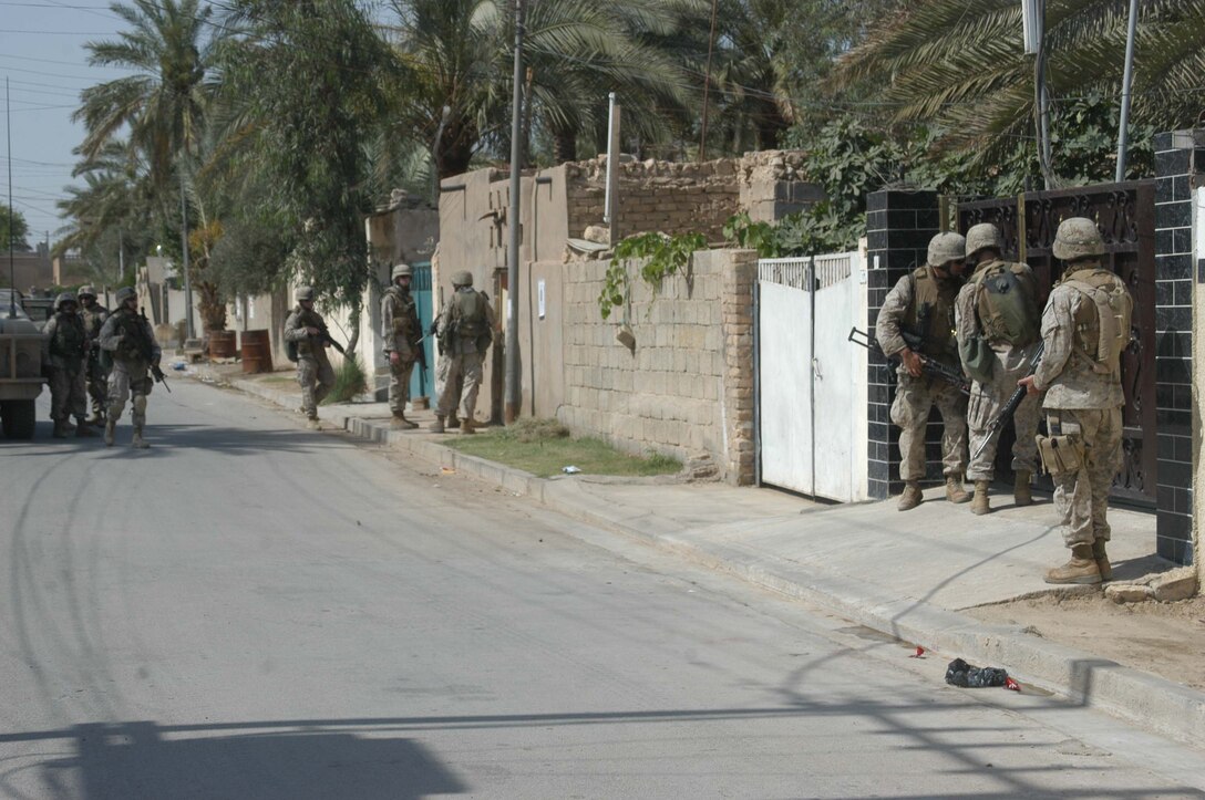 AR RAMADI, Iraq (May 27, 2005) - Marines with 4th Platoon, Company A, 1st Battalion, 5th Marine Regiment, prepare to enter a residence in the city here during a mission. The 4th Platoon warriors conducted a four-hour aggressive-foot-patrol through several neighborhoods and the city's marketplace. The Marines searched 12 houses and talked to numerous locals during the mission, which was conducted in an attempt to stifle insurgent activity and inform citizens why Marines and coalition forces are occupying Ramadi. The Marines handed out pro-coalition forces and pro-Iraqi government fliers, which had a number to call coalition forces to report insurgent activity. Photo by: Cpl. Tom Sloan