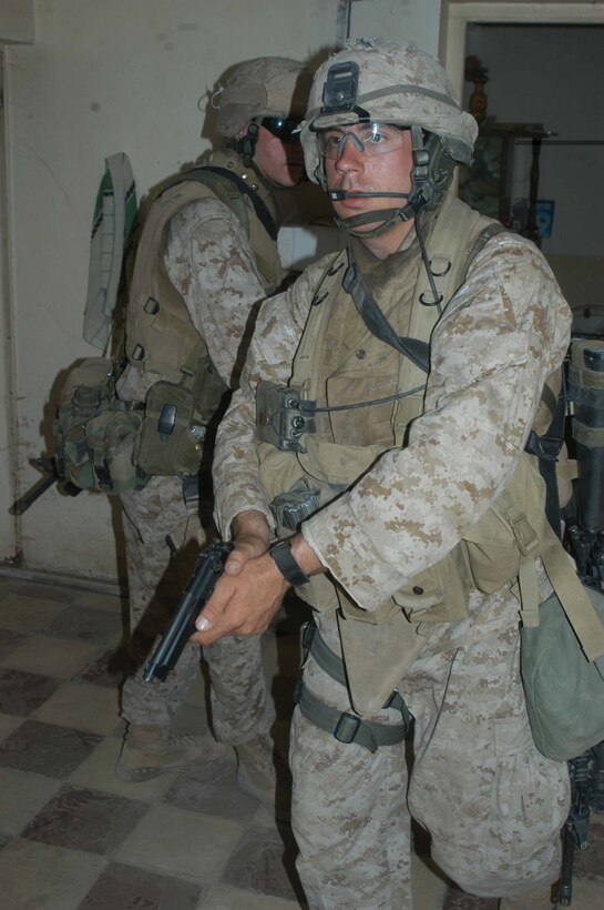 AR RAMADI, Iraq (May 29, 2005) - With his pistol drawn, Lance Cpl. Patrick A. Liegl, a rifleman and team leader with 3rd Squad, 4th Platoon, Company A, 1st Battalion, 5th Marine Regiment, searches a house in the city here with his fellow Marines. The 24-year-old from Central City, Iowa, and his fellow squad members searched several houses for weapons caches and questioned residents if they knew of insurgent activity. They also conducted a brief patrol through the marketplace where they talked to storeowners and shoppers and questioned them about insurgent activity. Photo by: Cpl. Tom Sloan