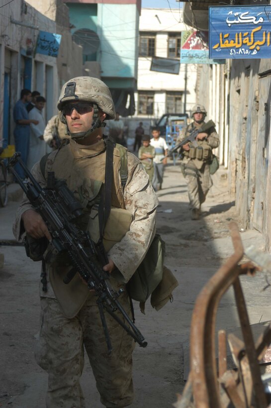 AR RAMADI, Iraq (May 29, 2005) - Lance Cpl. James E. Evans, a squad automatic machine gunner with 3rd Squad, 4th Platoon, Company A, 1st Battalion, 5th Marine Regiment, patrols through an alleyway in the city here with his fellow Marines. The 25-year-old from St. Louis and his fellow squad members searched several houses for weapons caches and questioned residents if they knew of insurgent activity. They also conducted a brief patrol through the marketplace where they talked to storeowners and shoppers and questioned them about insurgent activity. Photo by: Cpl. Tom Sloan