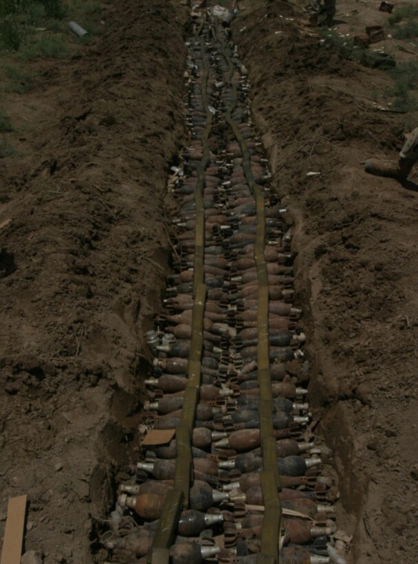 AL ANBAR PROVINCE, Iraq - Hundreds of mortar rounds lay in a trench with two lines of explosive placed on top in prepartion to destroy them in a controled detonation. These rounds were part of one of 41 weapons and ammunitions caches found with a 72 hour period beginning May 30.