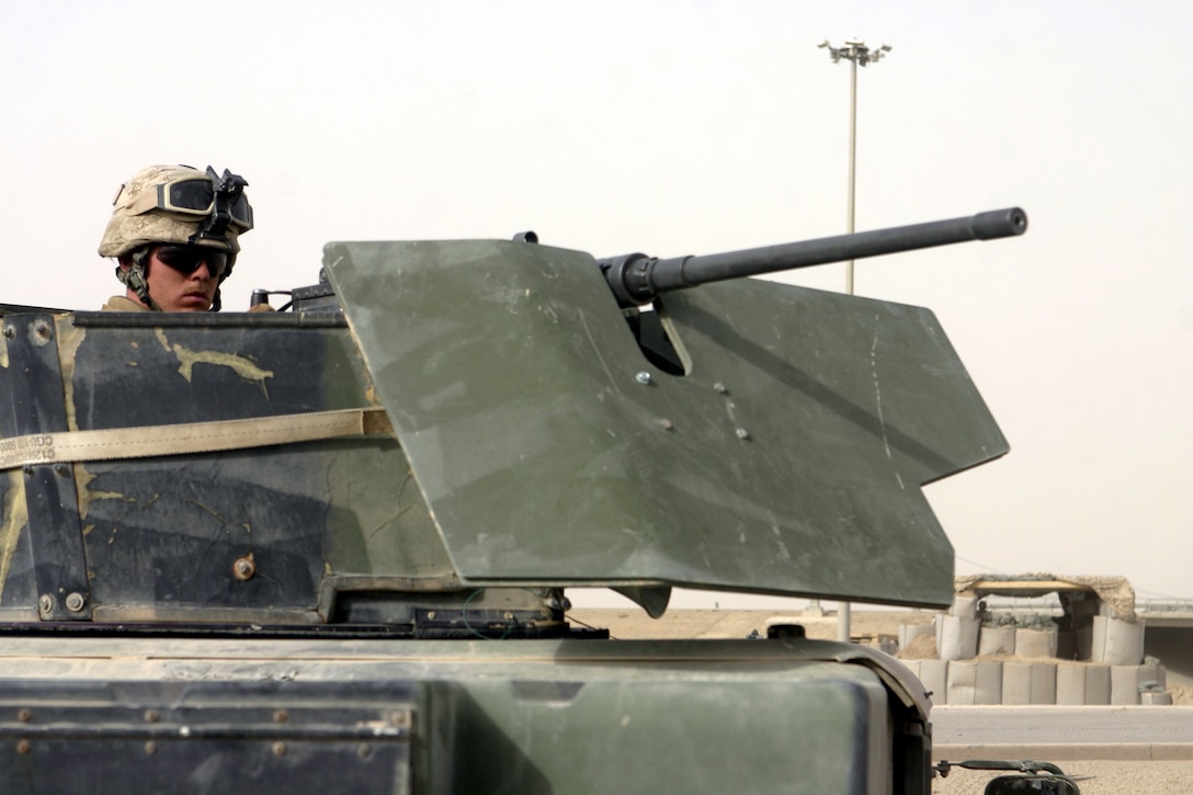 FALLUJAH, Iraq - A Marine with 81mm mortar platoon, Weapons Company, 1st Battalion, 6th Marine Regiment, stands behind a M2 .50 caliber machinegun while providing security for a supply and logistics run here July 18.  81mm mortar platoon Marines provide security for several daily 'log' runs in and around Fallujah to help re-supply the battalion's infantrymen with water, food, and equipment.