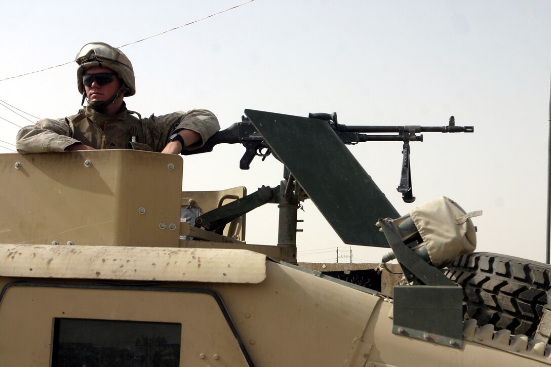 FALLUJAH, Iraq - A Marine with 2nd Combined Anti-Armor Team, Weapons Company, 1st Battalion, 6th Marine Regiment provides area security from atop his vehicle's gun turret here July 19 during Operation Rolling Barrage.  Weapons Company personnel worked alongside 1st Battalion, 6th Marine Regiment infantrymen, Iraqi Security Forces and mechanized supporting elements to block off sections of Fallujah, while roving infantrymen patrolled through the streets to disrupt insurgent activity.