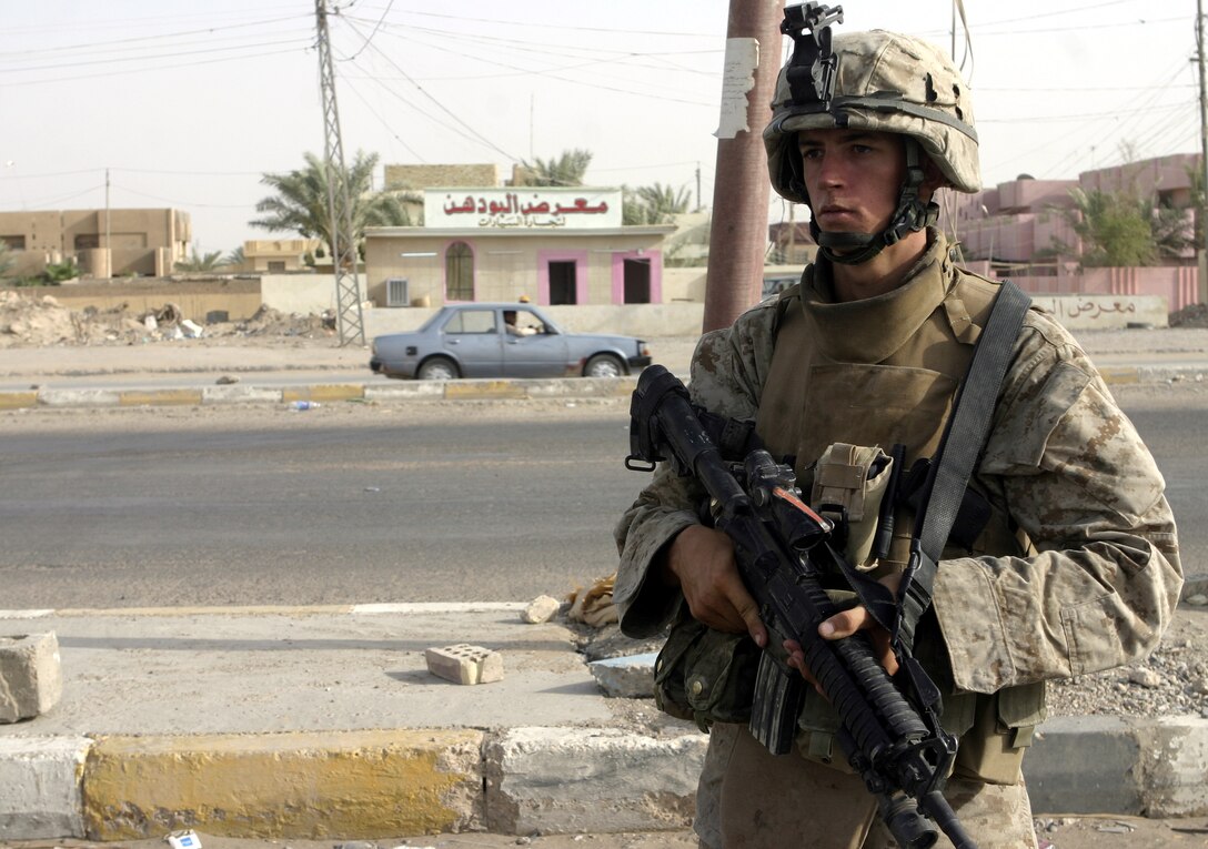 FALLUJAH, Iraq - Lance Cpl. Scott Redhead, an infantryman with 2nd Combined Anti-Armor Team, Weapons Company, 1st Battalion, 6th Marine Regiment, provides security along an intersection here during Operation Rolling Barrage.  The 21-year-old LaVale, Md. native worked alongside 1st Battalion, 6th Marine Regiment infantrymen, Iraqi Security Forces and mechanized supporting elements to block off sections of Fallujah, while roving infantrymen patrolled through the streets to disrupt insurgent activity.