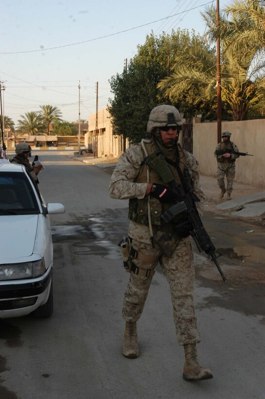 AR RAMADI Iraq (July 22, 2005) - Corporal Kelly P. Baker, a rifleman and team leader with 2nd Squad, 1st Platoon, Company C, 1st Battalion, 5th Marine Regiment, uses his radio to talk to his fellow Marines during a recent patrol in the city here July 22. Baker is a third generation American Indian serving in the Marine Corps during a time of conflict. The 21-year-old from New Town - a city inside Ft. Berthold Indian Reservation in North Dakota - is descendant of affiliated Great Plains tribes Mandan, Hidasta and Arikara. His grandfather, Clyde Baker, served during World War II and fought in the Battle of Okinawa. His father Hugh served during Vietnam. Both left the Corps as corporals. Photo by: Cpl. Tom Sloan