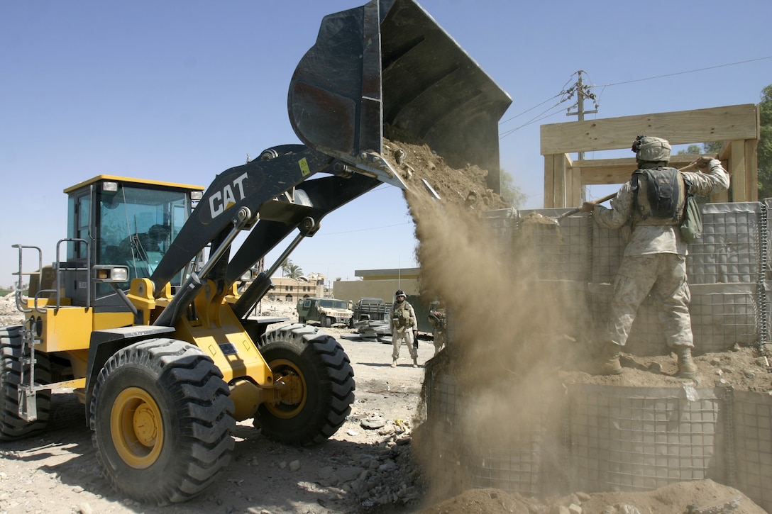 FALLUJAH, Iraq - Marines with 2nd Platoon, Company A, 2nd Combat Engineer Battalion fill barriers with dirt and rubble to fortify a new observation post they erected along the Euphrates River here Sept. 5.  Iraqi soldiers will man Observation Post Kilpela to monitor the city streets and riverbed's farm fields for insurgent activity, to include the placement of improvised explosive devices.
