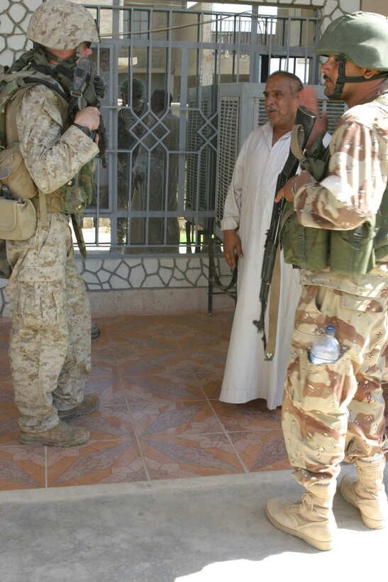HADITHA, Iraq ? A Marine with Company L, 3rd Battalion, 1st Marine Regiment and Iraqi security force soldier talk to a local man during operations to clear the city here Oct. 5. The operation, focused mostly on Haditha, also includes the cities of Haqlaniya and Darwana, where approximately 2,500 U.S. troops and 400 Iraqi security force soldiers clear the city of all insurgent activity.