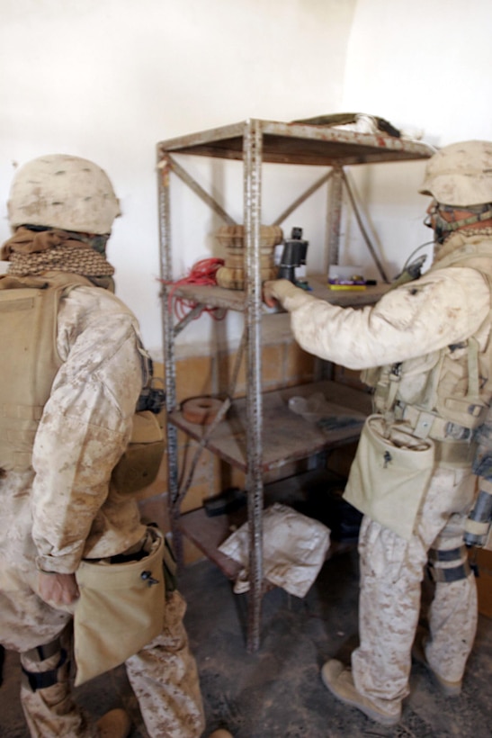Husaybah, Iraq ( November 5, 2005)--Sgt. Saul Pando, Jr. and Sgt. Robert E. Canales, with 2nd platoon, 1st LAR scouts sift through a small find inside a booby trapped house during Operation Steel Curtain. The two landmines shown were disabled but were still to unstable to move. (Official U. S. Marine Corps photo by Corporal Ken Melton)