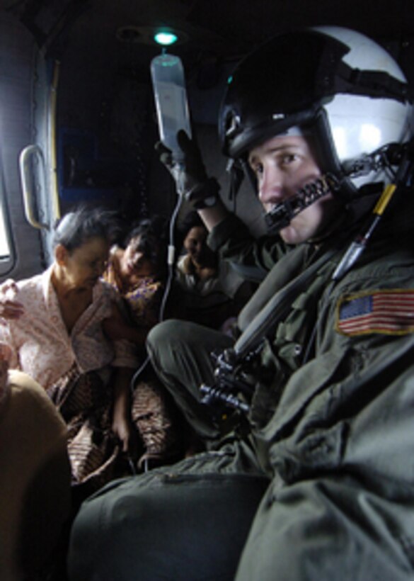 U.S. Navy Aircrewman Matt Gardner holds the IV bag of an Indonesian woman during a humanitarian aid mission to Banda Aceh, Sumatra, Indonesia, on Jan 4, 2005. Helicopters from the USS Abraham Lincoln (CVN 72) Carrier Strike Group are providing humanitarian assistance to areas devastated by the Dec. 26, 2004, tsunami that struck the Indian Ocean. The Lincoln Carrier Strike Group is currently operating in the Indian Ocean off the coasts of Indonesia and Thailand as part of Operation Unified Assistance. Gardner is from Phoenix, Ariz., and is assigned to Anti-Submarine Light Squadron 47. 