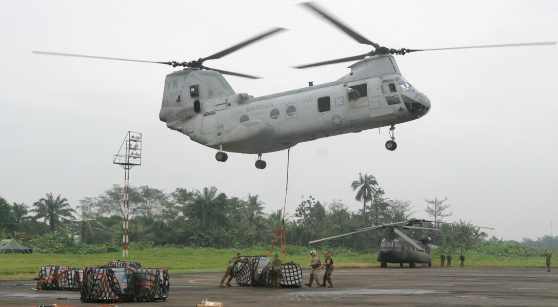 Marines with the 15th Marine Expeditionary Unit (Special Operations Capable) hook up humanitarian aid supplies to a CH-46E Sea Knight to be be flown out to USS Bonhomme Richard. The 15th MEU (SOC) will transport the supplies aroud the island of Sumatra where they will be distributed to victims of the recent tsunami.