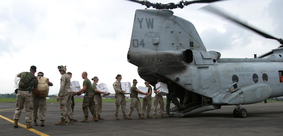 Marines with the 15th Marine Expeditionary Unit (Special Operations Capable) load boxes of humanitarian aid supplies onto a CH-46E Sea Knight to be flown to USS Bonhomme Richard. The 15th MEU (SOC) is scheduled to transport the supplies to the western side of Sumatra and distribute them to the victims of the recent tsunami.