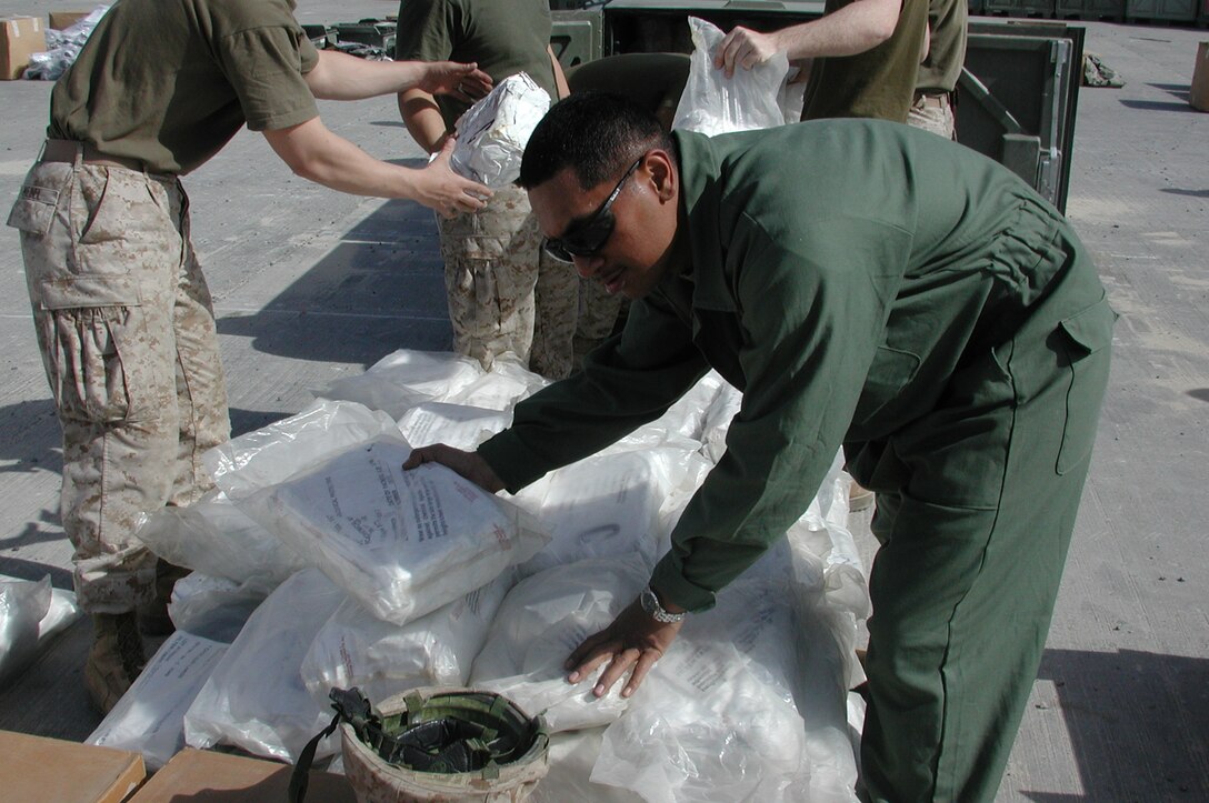 Lance Cpl. Konrad Nikolao, 21, a native of American Samoa, organizes a pile of Nuclear Biological Chemical suits as Marines prepare to clean a palletized container. The 15th Marine Expeditionary Unit (Special Operations Capable) recently completed their second combat tour in Iraq.
