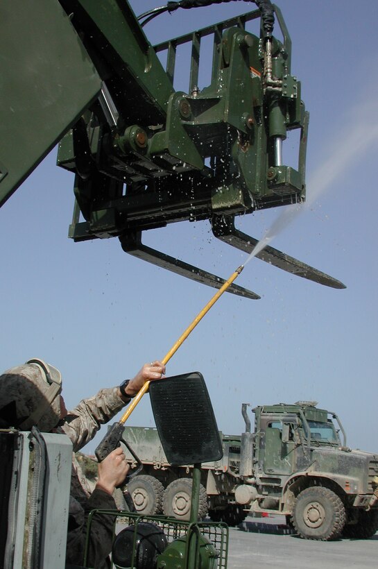 Sgt. James Kennington, a maintenance technician with MEU Service Support Group 15 and native of Texarkana, Texas, sprays dirt off the front of a forklift during a unit wash down. The 15th Marine Expeditionary Unit (Special Operations Capable) recently completed their second combat tour in Iraq.