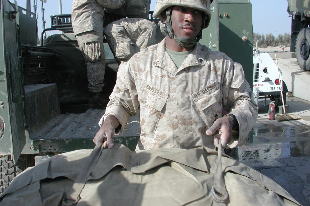 Cpl. David T. Smalley, 20, a field radio operator and native of Augusta, Ga., helps empty a truck during a unit wash down. The 15th Marine Expeditionary Unit (Special Operations Capable) recently completed their second combat tour in Iraq.