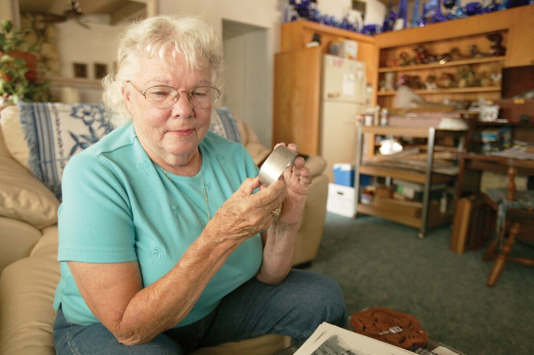 Mickey Urlie reminisces with an artifact of her late father's, made from the wreckage of a Japanese airplane on Iwo Jima
