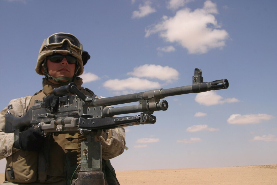 AL ASAD,Iraq-Lance Cpl. Michael Hahn, machine gunner, 3/2 keeps an eye on his fellow Lima Company Marines while they question an Iraqi civilian during their patrol, April 4.