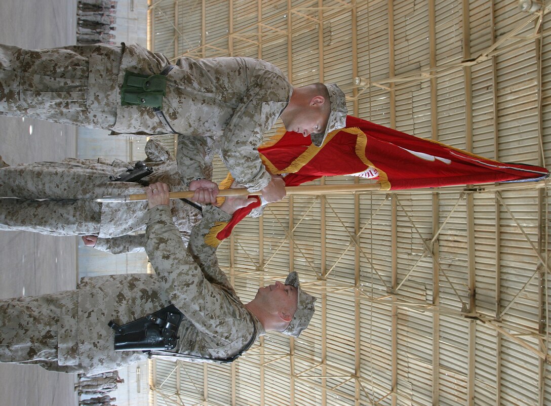 AL ASAD, Iraq ? Lt. Col. Jeffery A. Baumert, incoming commanding officer, Marine Fighter Attack Squadron 142, receives the squadron colors from Lt. Col. Charles B. Sagebiel, outgoing commander, May 6.  Baumert served as the squadron's executive officer and takes command from Sagebiel, who led the Gators to Iraq in the first deployment to combat in 50 years for a reserve fixed wing fighter squadron.