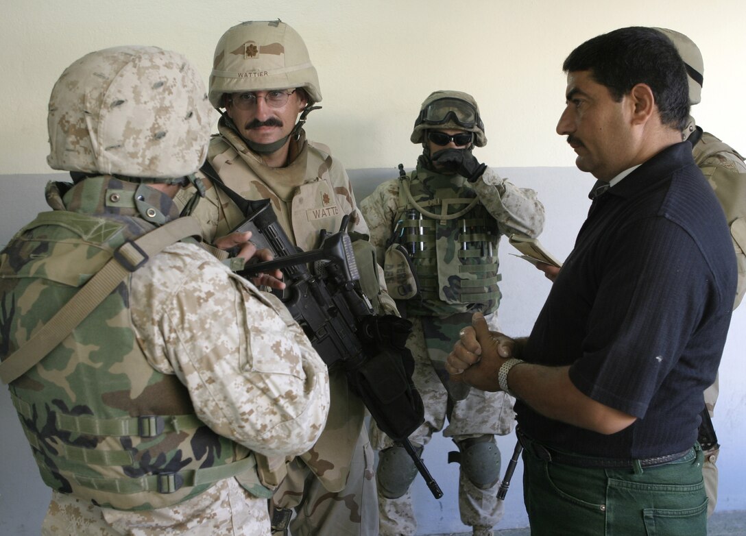 FALLUJAH, Iraq - Maj. Tim Wattier, Team "Regulators," Company B, 445th Civil Affairs Battalion, speaks with a local contractor through an interpreter at the Marjan school here May 31.  Wattier's team worked alongside local contractors to install new fixtures, doors and electric wiring throughout the school.