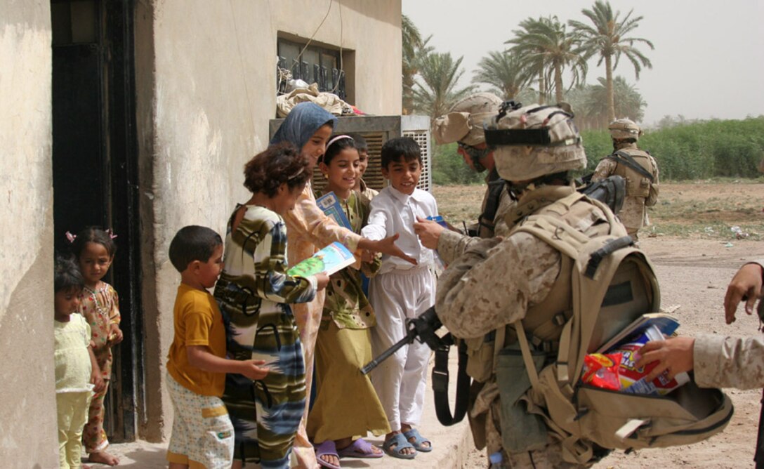050906-M-2607O-003 CAMP FALLUJAH, Iraq -- Marines from Company G, 2nd Battalion, 2nd Marine Regiment, hand out candy and toys to the local children during a patrol in their area of operation on Sept. 6.  The patrols were conducted to find the village leaders to see what the village needed that the Marines could try and provide at a later date.