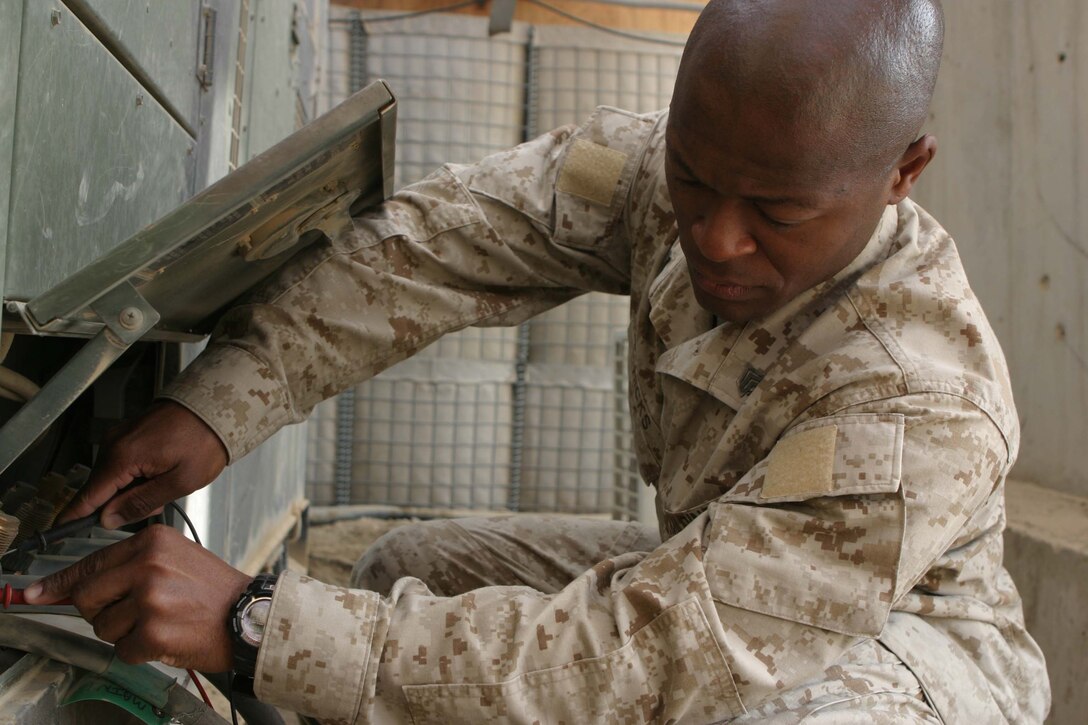 CAMP BLUE DIAMOND, RAMADI, Iraq - Sergeant Derrick L. Hicks, an electrical equipment repairman, Headquarters Battalion, 2nd Marine Division, test the voltage on a generator here. Hicks provides the electricity that keeps the 2nd Marine Division's Communications Company up and running. Communications Company provides the main conduit for all internet, phone and radio communications flowing into and out of the camp which houses the 2nd Marine Division's Headquarters. Official U.S. Marine Corps photo by Sgt. Ryan S. Scranton