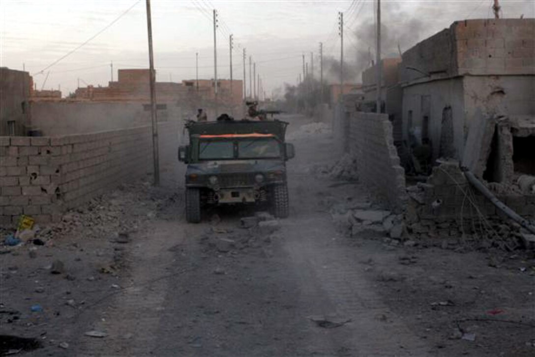 HUSAYBAH, Iraq ? Marines in the back of a humvee keep watch for possible snipers as they move through a street here, Nov. 6. The Marines, assigned to Headquarters and Service Company, 2nd Battalion, 1st Marine Regiment, and Iraqi soldiers with 1st Battalion, 1st Brigade, 1st Division, Iraqi Army, participated in the recent offensive against insurgents within border towns on the Lower Euphrates River Valley.