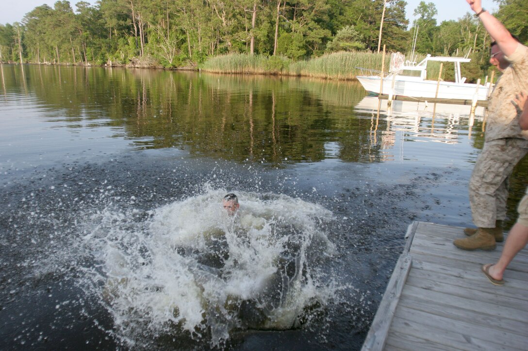 As part of a time-honored tradition, Gunnery Sgt. Alvin W. Thomas, former first sergeant of Small Craft Company, was dumped in the waters here for a final swim.  After 20 years in the Marine Corps, many of which were spent at Small Craft Company, he retired June 6 during the company's decomissioning ceremony.