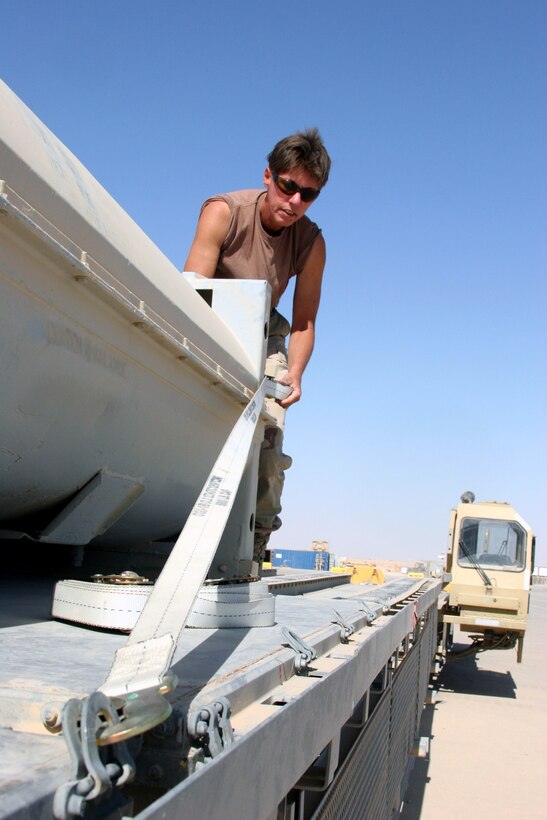AL ASAD, Iraq - Petty Officer 2nd Class Kathryn VanHooser, a Springfield, Mo., native with Mobile Air Cargo Handling Team 3 prepares a pallet for shipment on the flightline here June 7. VanHooser is a deputy sheriff in Missouri and this is her second time to Iraq. She deployed the first time in 2003 with 4th Medical Battalion from Camp Pendleton, Calif.