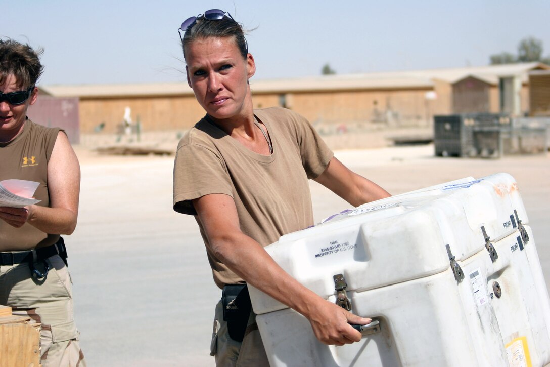 AL ASAD, Iraq ? Petty Officer 3rd Class Sara Trimble, a Neosho, Mo., native with Mobile Air Cargo Handling Team 3 carries a box of gear to be palletized before its shipment to a forward operating base. The cargo handling team is half way through their scheduled six month deployment.