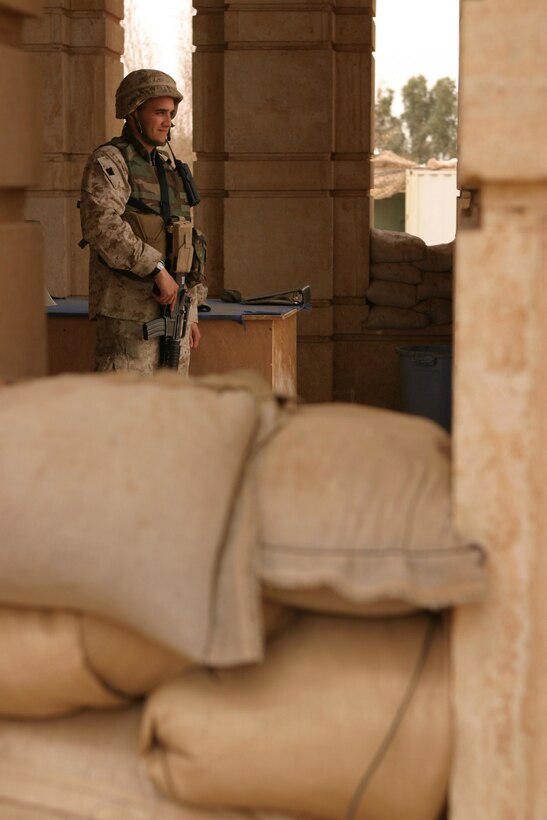 Private First Class Augustin Melendez, a 22-year-old special intelligence communicator and administrator with 2d Radio Battalion, 2d Marine Division, stands guard outside of the division's combat operations center.  The Roselle Park, N.J. native rotates between guarding the COC, where all 2d Marine Division missions are tracked, to handling insurgent detainees and even guarding the mess hall while Marines and other service members eat.  Melendez is one of the Marines on the camp's security force, keeping an eye out for anything suspicious - day or night.  Official U.S. Marine Corps photo by Sgt. Stephen D'Alessio (RELEASED)