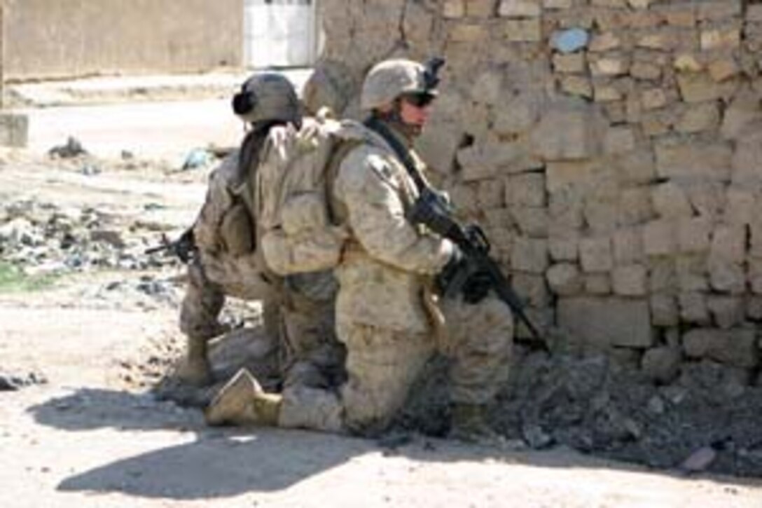 CAMP ABU GHURAYB, IRAQ ? Marines from Company K, 3rd Battalion, 8th Marine Regiment stop and find cover at the sound of what was possibly small arms fire.  Only days after a large attack on Abu Ghurayb Prison, the Marines patrol the streets carefully keeping their eyes peeled for any suspicious activity in the area.