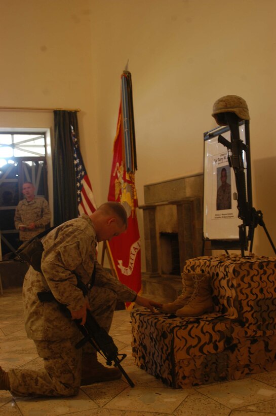 CAMP HURRICANE POINT Ar Ramamdi, Iraq (April 7, 2005) - Corporal Robert T. Harriott, rifleman, 2nd Platoon, Company W, 1st Battalion, 5th Marine Regiment, kneels at the foot of a memorial set up for Cpl. Garry W. Rimes and pays tribute to the fallen warrior. Harriott was with Rimes at the time of his death. A memorial service was held here for the 30-year-old rifleman and scout with 2nd Platoon, Company W, 1st Battalion, 5th Marine Regiment, who was killed by enemy sniper fire while fighting the Global War on Terrorism. Rimes, from Rizal, Philippines, is survived by his wife, Happy. Photo by Cpl. Tom Sloan