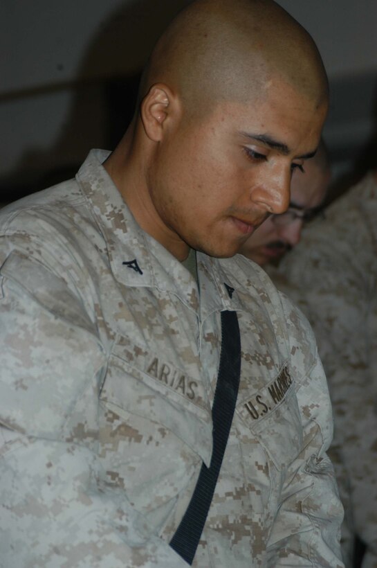 CAMP HURRICANE POINT Ar Ramamdi, Iraq (April 7, 2005) - Lance Cpl. Eduardo Arias, machine gunner, 2nd Platoon, Company W, 1st Battalion, 5th Marine Regiment, bows his head and remembers the type of Marine and personal friend Cpl. Garry W. Rimes was during a memorial ceremony here. The 30-year-old rifleman and scout with 2nd Platoon, Company W, 1st Battalion, 5th Marine Regiment, was killed by enemy sniper fire while fighting the Global War on Terrorism. Rimes, from Rizal, Philippines, is survived by his wife, Happy. Photo by Cpl. Tom Sloan