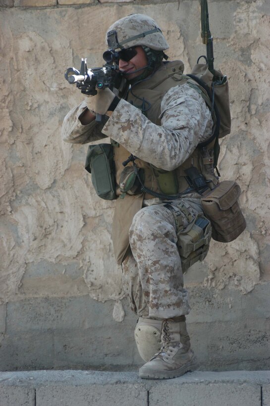 AR RAMADI, Iraq (May 7, 2005) - Sergeant Fidel A. Alcoces, platoon sergeant, 2nd Platoon, Company A, 1st Battalion, 5th Marine Regiment, positions himself beside a wall here and posts security while conducting an operation with his fellow leathernecks.  The 29-year-old San Antonio, Texas, native and other warriors with the infantry battalion's Company's A, C and W conducted "Operation Weston," which was a three-hour cordon and search mission of a neighborhood. The purpose of the mission was to eradicate the area of insurgents and inform the people living there of the consequences for harboring terrorists. The Marines hit three improvised explosive devises and found one 155 mm shell. One Marine received minor shrapnel wounds, and no insurgents were captured. Photo by Cpl. Tom Sloan