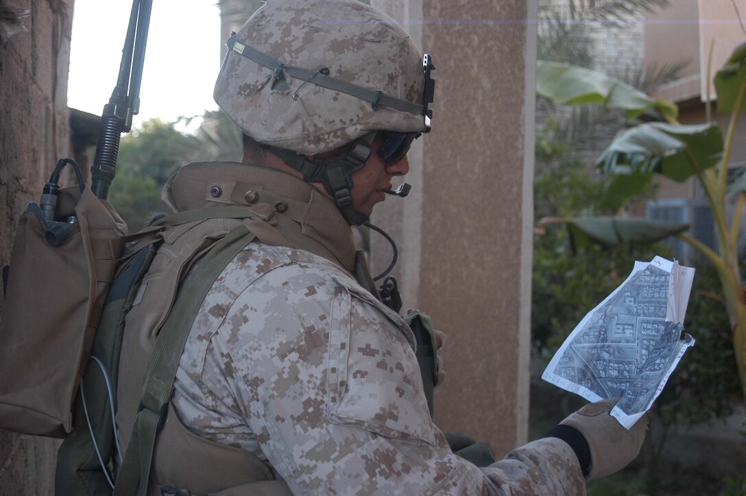 AR RAMADI, Iraq (May 7, 2005) - Sergeant Fidel A. Alcoces, platoon sergeant, 2nd Platoon, Company A, 1st Battalion, 5th Marine Regiment, checks his map during an operation here with his fellow leathernecks. The 29-year-old San Antonio, Texas, native and other warriors with the infantry battalion's Company's A, C and W conducted "Operation Weston," which was a three-hour cordon and search mission of a neighborhood. The purpose of the mission was to eradicate the area of insurgents and inform the people living there of the consequences for harboring terrorists. The Marines hit three improvised explosive devises and found one 155 mm shell. One Marine received minor shrapnel wounds, and no insurgents were captured. Photo by Cpl. Tom Sloan